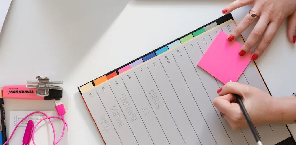 Hands planning with a notebook and sticky notes