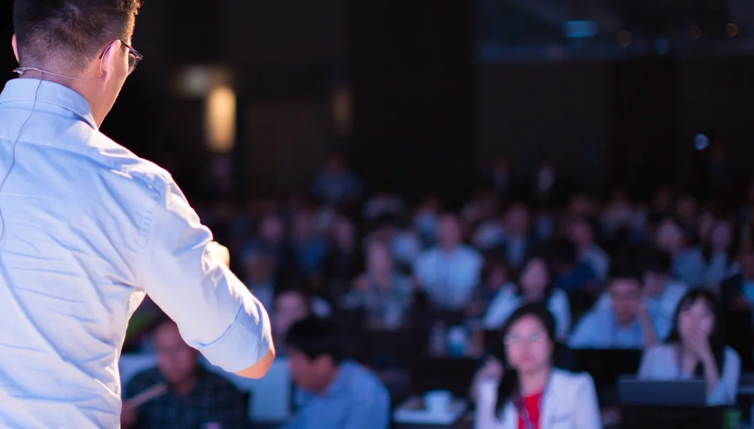 Speaker addressing a seated conference audience