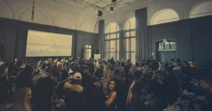 Top 5 Online Event Sign-Up Software You Need in 2024 Audience seated in front of a large projection screen