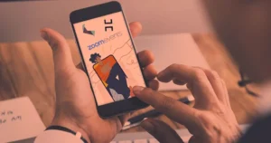 19 Must-Have Mobile Event Apps to Try in 2024 A man holding a smartphone with an image of a cartoon character on it.