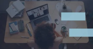 From Webinars to Workshops: 13 Interactive Meeting Ideas A woman attending an interactive meeting while sitting at a desk with a laptop in front of her.