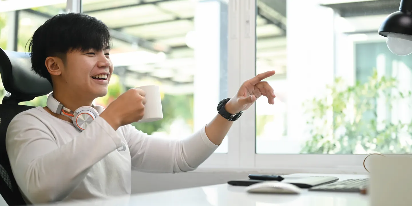 Colleague laughing and pointing during a video call