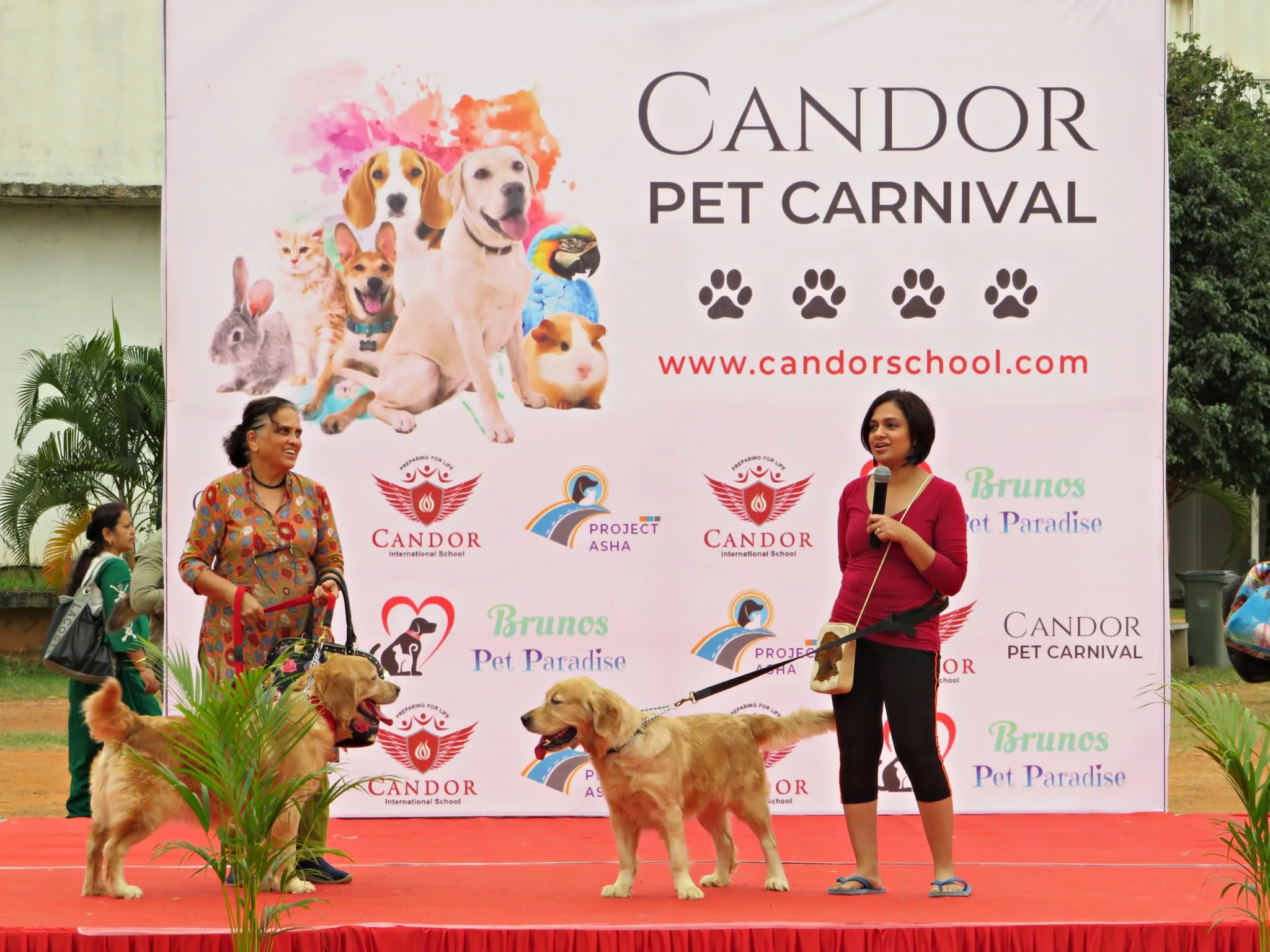 Candor Pet Carnival outdoor event with attendees and dogs in front of the event banner