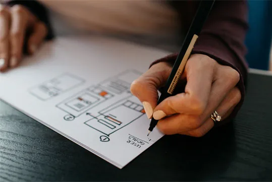 Hand sketching a plan diagram on paper