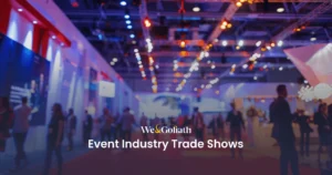 The Essential Blueprint for Thriving at Event Trade Shows Attendees at a busy event industry trade show with exhibition stands and lighting in the background.