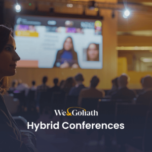 Hybrid Conference Best Practices for Success Woman attending a hybrid conference with both in-person and virtual elements, presented by we&goliath.
