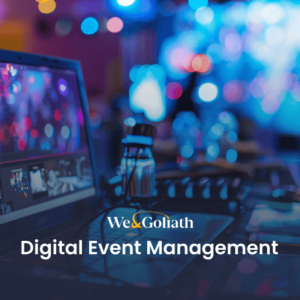 A computer on a desk displays a digital event setup with colorful lights in the background. Text reads "We & Goliath Digital Event Management.