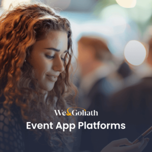 A woman with curly hair is using a smartphone at an event. The text "We & Goliath Event App Platforms" is prominently displayed. Several other blurred people are in the background.