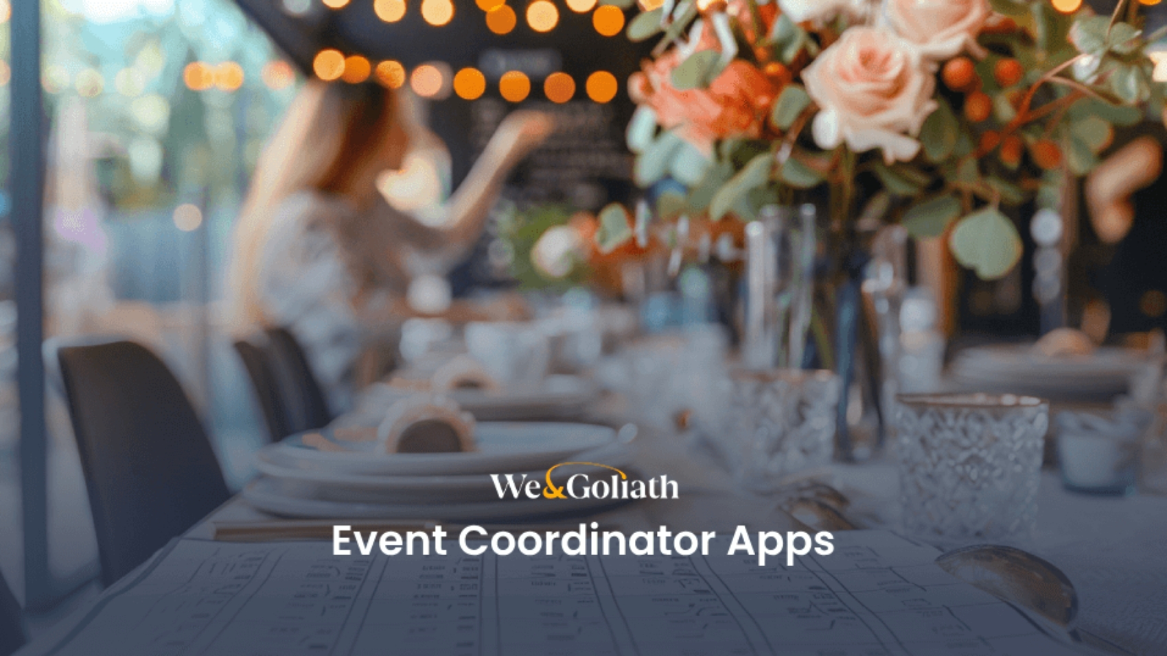 A blurred background of an event setting with flower arrangements and tableware, highlighted by the text "We & Goliath Event Coordinator Apps" in the foreground.