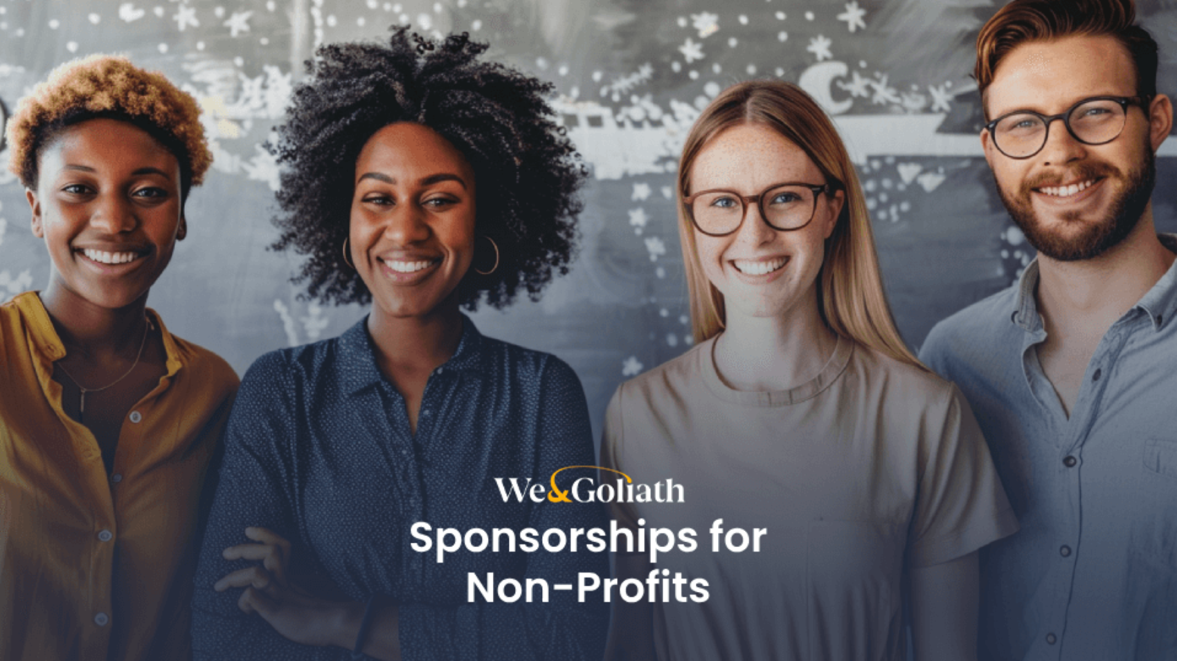 A diverse group of four smiling people stands in front of a chalkboard. A text overlay reads, "We & Goliath Sponsorships for Non-Profits.