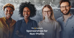 Creating Meaningful Collaborations for Non-Profits A diverse group of four smiling people stands in front of a chalkboard. A text overlay reads, "We & Goliath Sponsorships for Non-Profits.