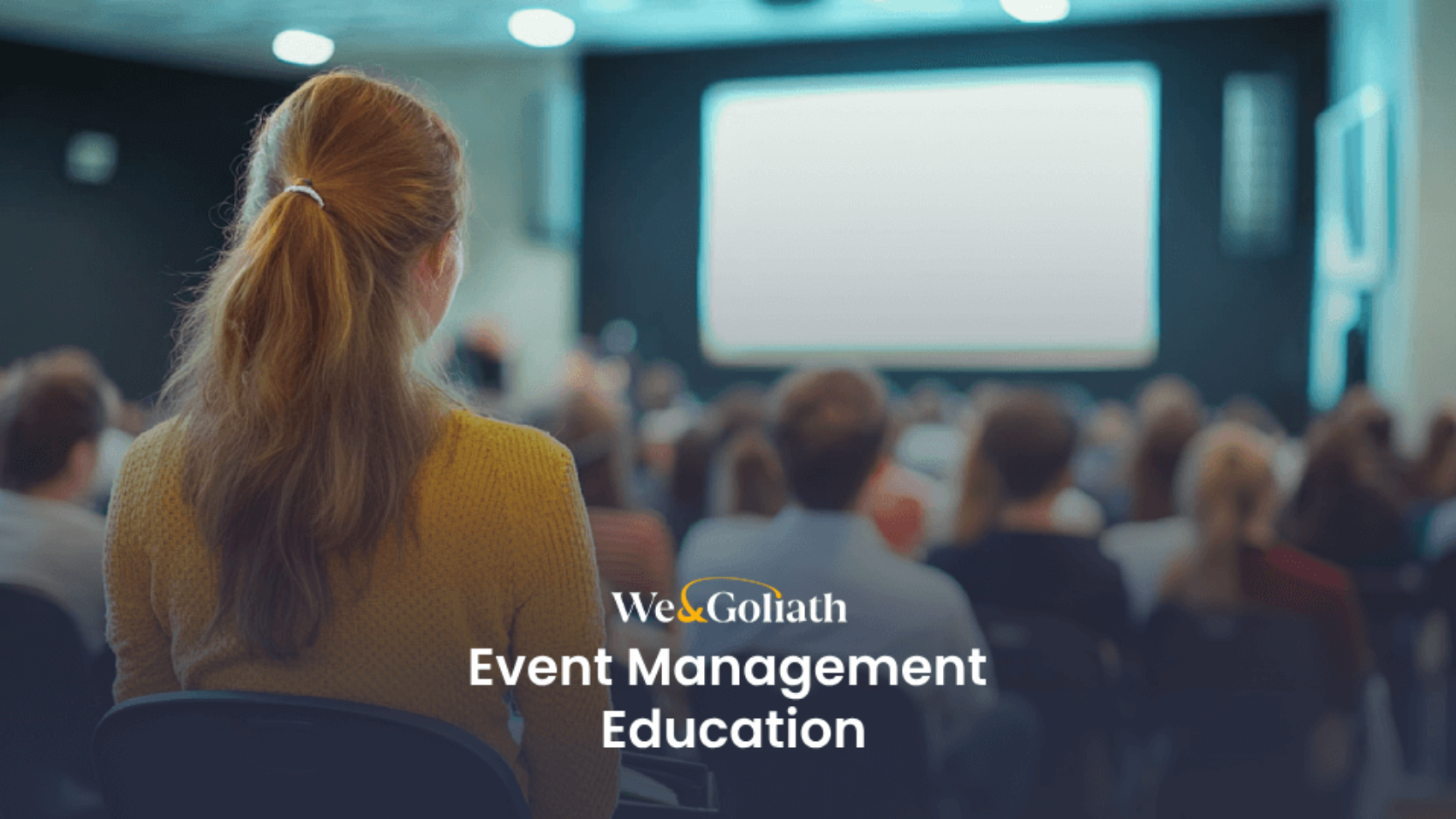 A person attends a presentation in a dimly lit auditorium, with a screen in front and an audience seated. Text reads "We & Goliath Event Management Education," providing insight into the intricacies of coordinating successful events.