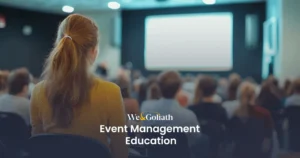 Essential Insights into Education and Credentials for Event Professionals A person attends a presentation in a dimly lit auditorium, with a screen in front and an audience seated. Text reads "We & Goliath Event Management Education," providing insight into the intricacies of coordinating successful events.