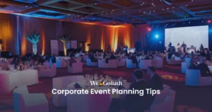 Mastering Corporate Gatherings: Strategies and Insights We and Goliath cover for corporate event planning tips, showing a large lit banquet hall