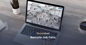 An Introduction to Remote Job Fairs: Navigating Virtual Hiring Events We and Goliath cover for remote job fairs, showing a virtual careers hall on a laptop